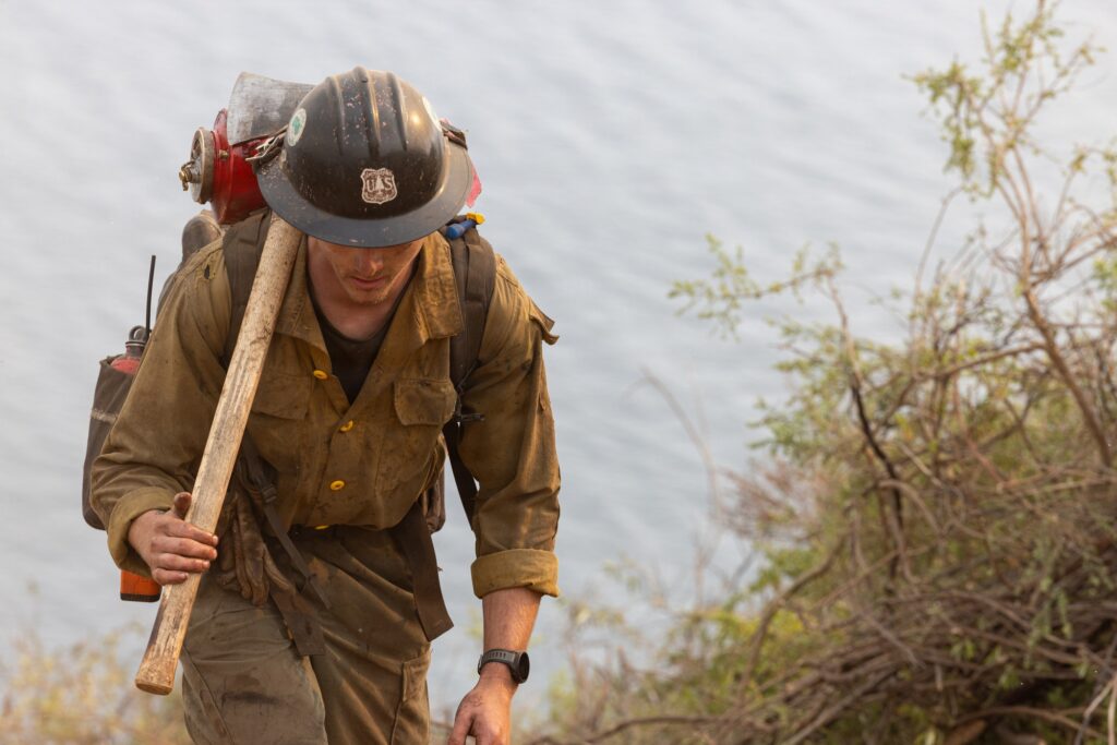 Laguna Hotshot hiking a control line with drip torch on the Timber Fire near Big Sur. U.S. Forest Service.